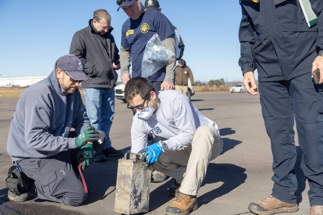 File photo: Aviation safety investigators examine a recovered flight recorder on an airport tarmac. Illustrative context; not a photograph of the reported event.
